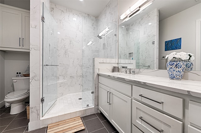 bathroom featuring tile patterned flooring, toilet, an enclosed shower, and vanity