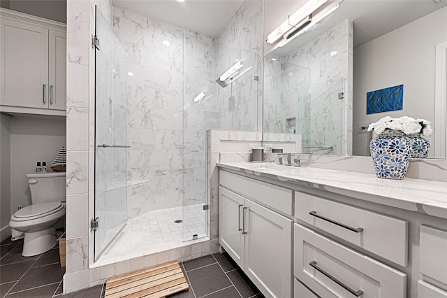 full bath featuring vanity, a stall shower, tile patterned flooring, and toilet