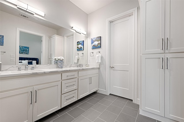 bathroom with double vanity, ensuite bath, a sink, and tile patterned floors