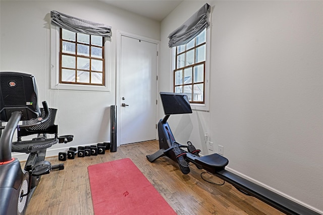 workout area with light wood-style flooring and baseboards