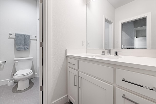 bathroom featuring tile patterned flooring, vanity, toilet, and baseboards