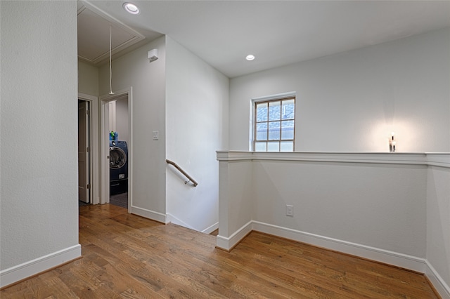 unfurnished room featuring washer / dryer and hardwood / wood-style flooring