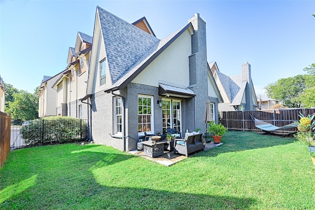 back of house featuring a shingled roof, a lawn, a fenced backyard, and brick siding