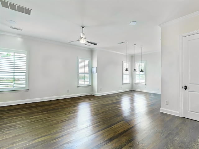 spare room featuring dark wood-style floors, a wealth of natural light, visible vents, ornamental molding, and ceiling fan