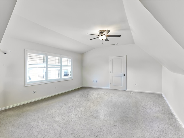 additional living space with carpet, visible vents, vaulted ceiling, and baseboards