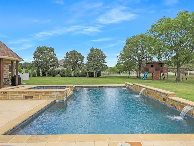 view of swimming pool featuring a lawn, a fenced backyard, a patio area, a pool with connected hot tub, and a playground