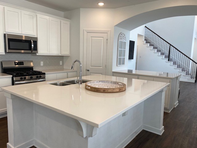 kitchen featuring sink, stainless steel appliances, and a center island with sink