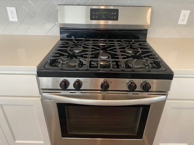 details with backsplash and gas stove