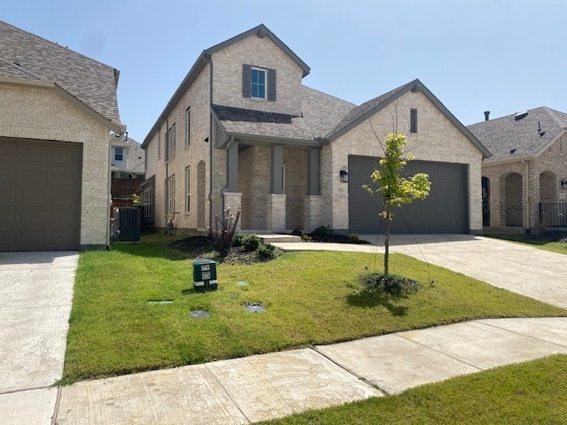 french provincial home with a garage, cooling unit, and a front yard