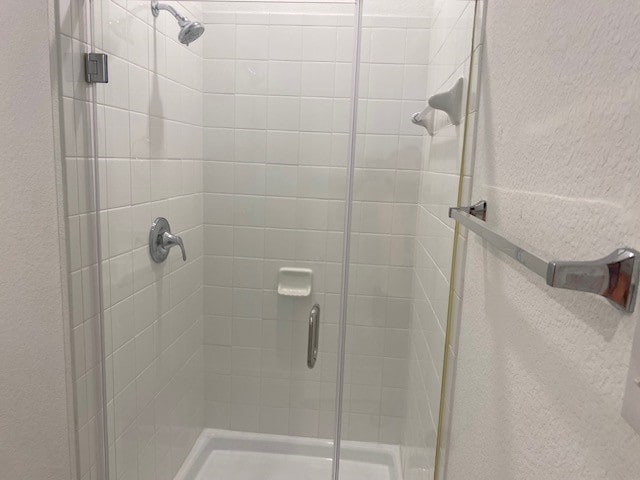 bathroom featuring a shower with door