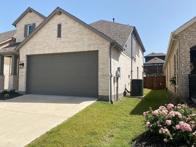 exterior space with cooling unit, a garage, and a yard