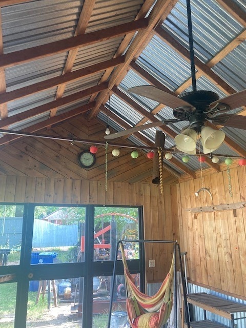 details with beam ceiling, wood walls, and ceiling fan