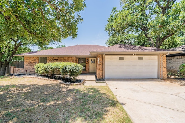 ranch-style house featuring a garage, brick siding, and driveway