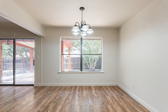 empty room featuring a chandelier and hardwood / wood-style flooring