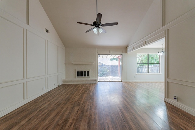 unfurnished living room with visible vents, dark wood-style floors, ceiling fan, a brick fireplace, and a decorative wall