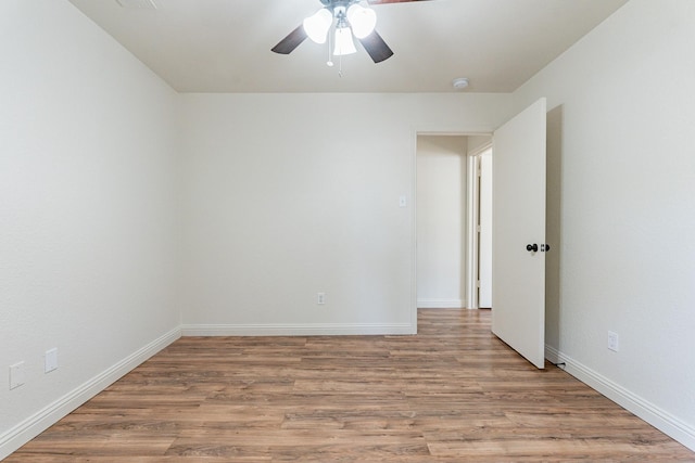 spare room with a ceiling fan, baseboards, and wood finished floors