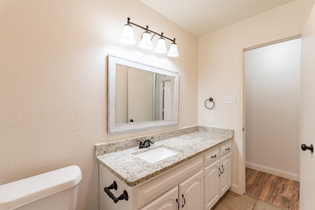 bathroom featuring hardwood / wood-style floors, vanity, and toilet