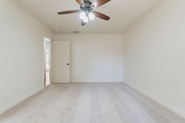 unfurnished room with visible vents, ceiling fan, light carpet, and baseboards