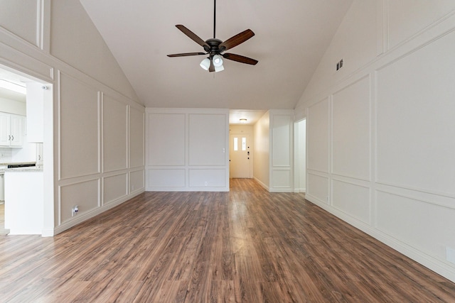 unfurnished living room featuring dark wood-type flooring, a decorative wall, and a ceiling fan