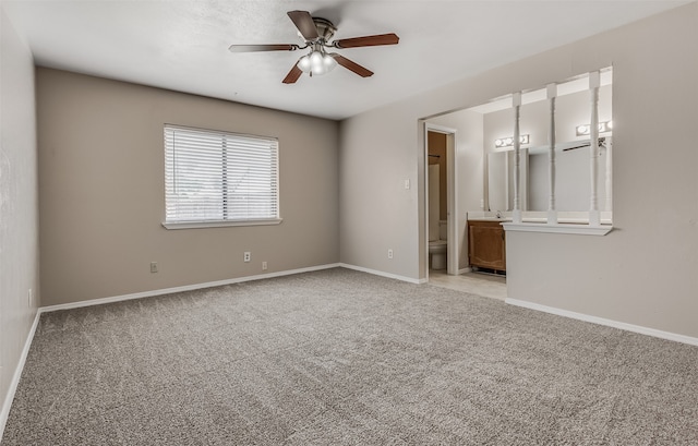 carpeted spare room featuring ceiling fan