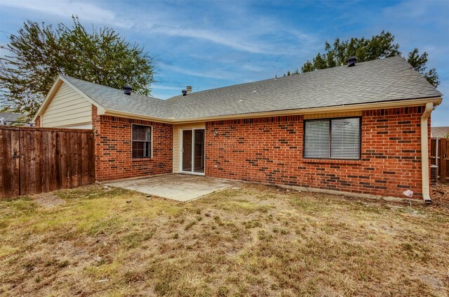 rear view of property with a yard and a patio