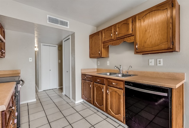 kitchen with black appliances, light tile patterned floors, and sink