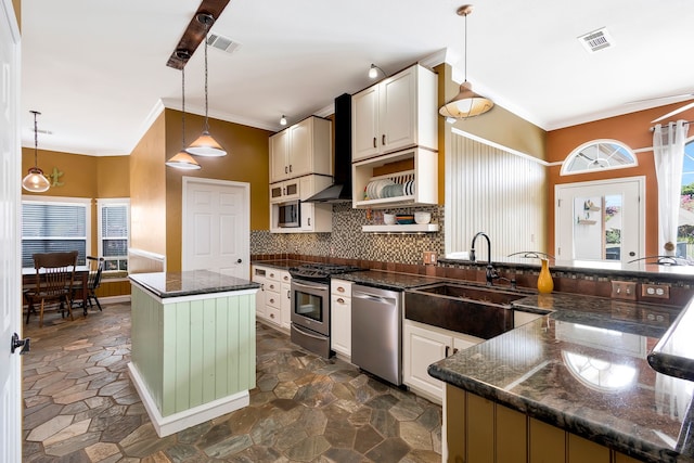 kitchen featuring sink, a center island, hanging light fixtures, appliances with stainless steel finishes, and backsplash