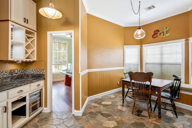 dining area with crown molding and beverage cooler