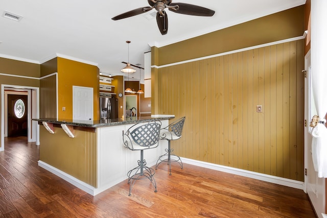 kitchen featuring decorative light fixtures, stainless steel fridge with ice dispenser, ornamental molding, kitchen peninsula, and ceiling fan