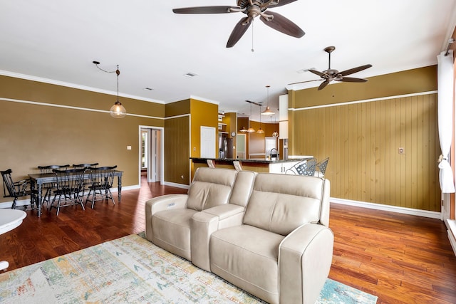 living room featuring crown molding, wood-type flooring, and ceiling fan