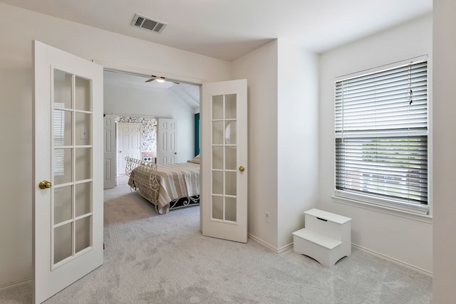 bedroom featuring light colored carpet and french doors