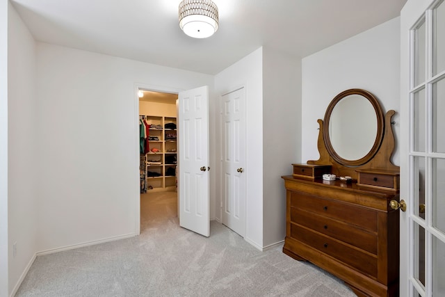 carpeted bedroom featuring a spacious closet and a closet