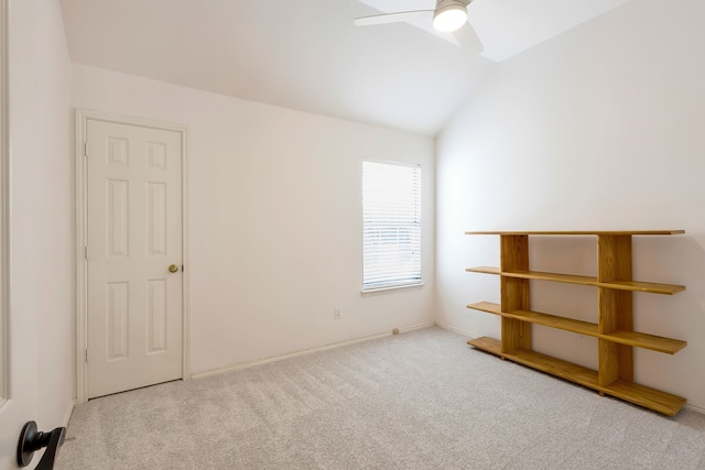 spare room with lofted ceiling, light colored carpet, and ceiling fan