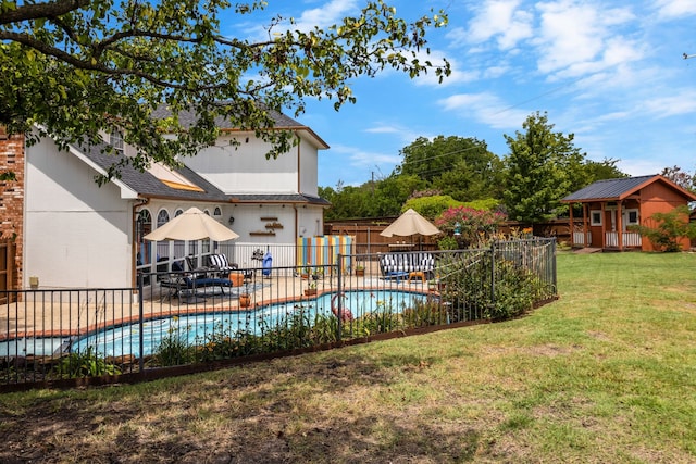 view of swimming pool with a patio, a lawn, and a storage unit