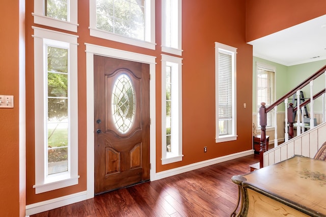 entryway with crown molding, dark wood-type flooring, and plenty of natural light