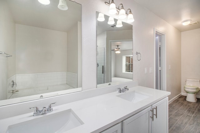 bathroom featuring double vanity, hardwood / wood-style flooring, a bath, and toilet