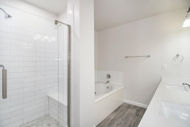 bathroom with plus walk in shower, hardwood / wood-style floors, and double sink vanity