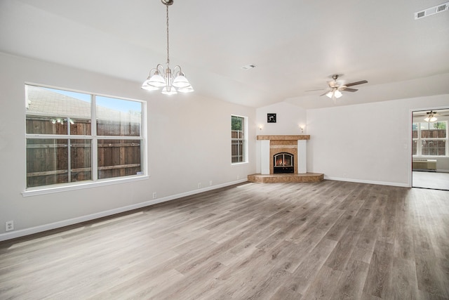 unfurnished living room featuring vaulted ceiling, ceiling fan with notable chandelier, and hardwood / wood-style floors