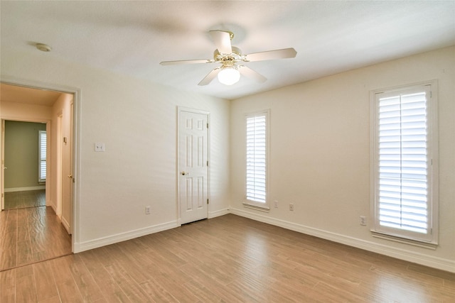 empty room with ceiling fan and light hardwood / wood-style floors