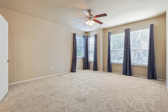 unfurnished room with light colored carpet and ceiling fan