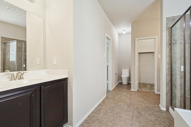 bathroom featuring tile patterned floors, toilet, vanity, and an enclosed shower