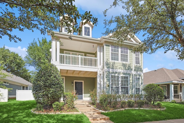 view of front of property featuring a balcony and a front lawn