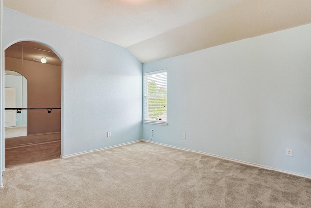 unfurnished room with carpet floors and vaulted ceiling