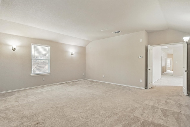 carpeted spare room featuring lofted ceiling