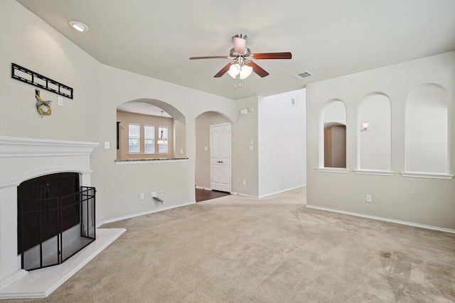 unfurnished living room featuring carpet and ceiling fan