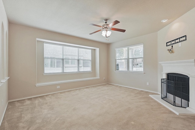 unfurnished living room with light colored carpet and ceiling fan