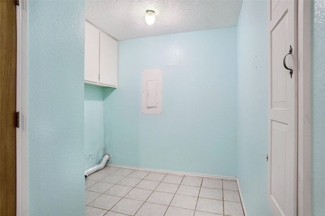 washroom featuring cabinets, electric panel, light tile patterned floors, and a textured ceiling