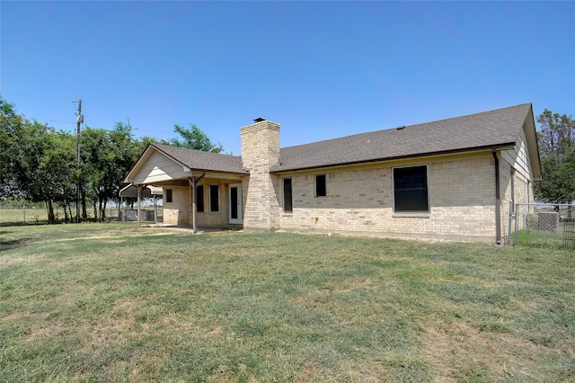 rear view of house featuring a lawn