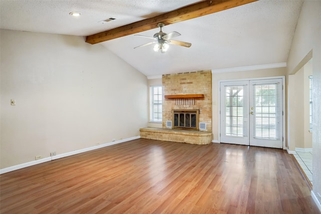 unfurnished living room featuring vaulted ceiling with beams, a fireplace, and hardwood / wood-style floors