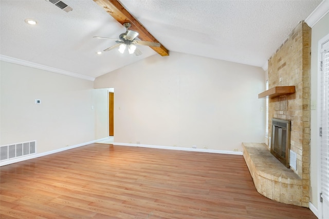 unfurnished living room featuring vaulted ceiling with beams, hardwood / wood-style flooring, a fireplace, a textured ceiling, and ceiling fan